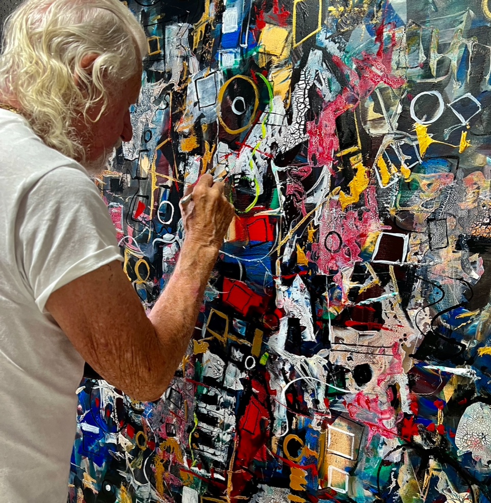 Paul Ygartua in his studio beneath a large portrait painting